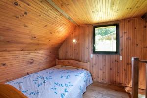 a bedroom with a bed in a wooden cabin at Gite Anje in Peyrouse