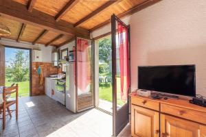 a kitchen with a flat screen tv on a wall at Gite Anje in Peyrouse