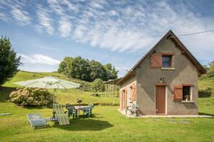 a small house with a table and an umbrella at Gite Anje in Peyrouse