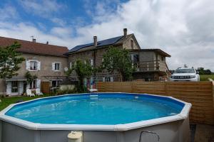 a large hot tub in front of a house at La Salamandre in Saint-Agrève