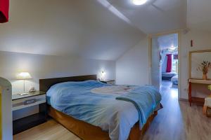 a bedroom with a large bed with a blue blanket at La Salamandre in Saint-Agrève +25 photos