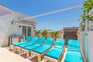 a row of blue beach chairs on a balcony at Villa Carolima - Heated Pool in Benissa