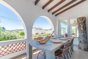 a dining room with a table and chairs and windows at Villa Carolima - Heated Pool in Benissa
