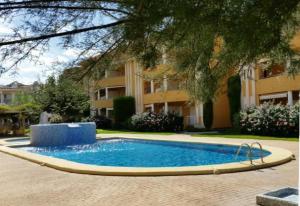 a swimming pool in front of a building at Denia Living in Denia