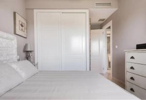 a white bedroom with a large bed and a closet at Denia Living in Denia +14 photos