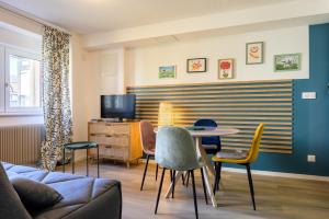 a living room with a table and chairs at Au Bretzel in Ostheim