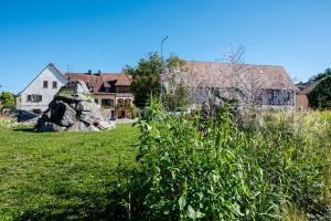 a house and a yard with a rock in the grass at Au Bretzel in Ostheim