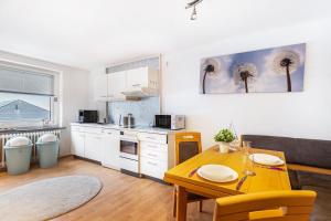 a kitchen with a wooden table and a dining room at Ferienwohnung Seestern in Wester-Ohrstedt