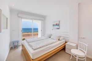 a bedroom with a bed and a large window at Casa Miramar in Sa Ràpita