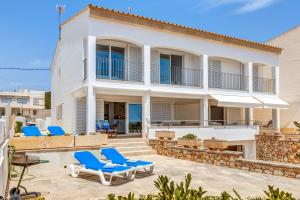 a villa with a swimming pool and blue lounge chairs at Casa Miramar in Sa Ràpita