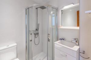 a white bathroom with a shower and a sink at Casa Miramar in Sa Ràpita +17 photos
