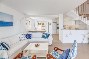 a white living room with a couch and a table at Casa Miramar in Sa Ràpita