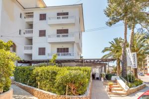 a large white building with trees in front of it at Apartamento La Cabanya 2d in Canyamel
