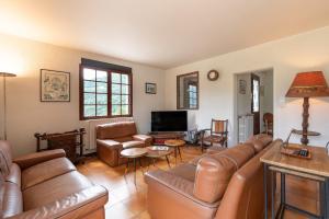 a living room with leather furniture and a television at Villa Delb in Arthez-dʼAsson