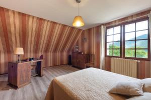 a bedroom with a bed and a desk and a window at Villa Delb in Arthez-dʼAsson