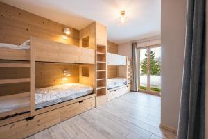 a room with wooden bunk beds in a house at Alphonsine Ski Lodge in La Toussuire