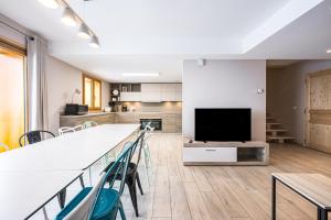 a kitchen and living room with a large table and chairs at Alphonsine Ski Lodge in La Toussuire