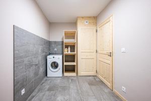 a laundry room with a washing machine and a door at Alphonsine Ski Lodge in La Toussuire