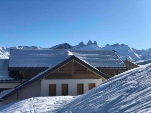 a house in the snow with mountains in the background at Alphonsine Ski Lodge in La Toussuire