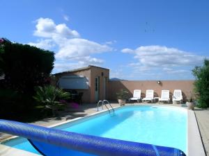 a swimming pool in a yard with chairs at Gite La Roseraie in Ruoms