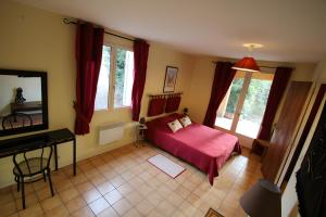 a bedroom with a bed and a piano in a room at Gite La Roseraie in Ruoms