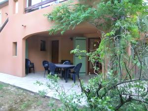 a patio of a house with a table and chairs at Gite La Roseraie in Ruoms