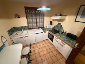 a small kitchen with white cabinets and a sink at Gite La Roseraie in Ruoms