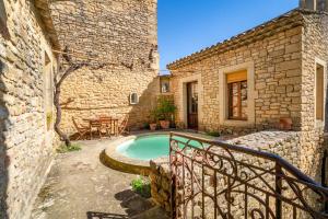 a courtyard with a pool in a stone house at Au Fil Des 5 Saisons in Vers Pont du Gard