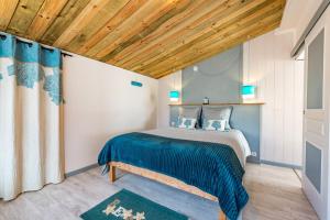 a bedroom with a bed and a wooden ceiling at Ty Reuniou - La Grange in Cléder