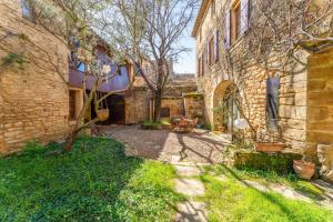 a courtyard of an old brick building with a table at Au Fil Des 5 Saisons in Vers Pont du Gard