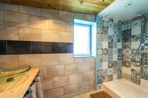 a bathroom with a sink and a tub and a window at Ty Reuniou - La Grange in Cléder +18 photos