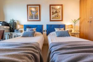 two beds in a room with blue headboards at Cambrils seaside luxury solarium in Montroig +29 photos
