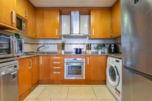 a kitchen with wooden cabinets and a stainless steel refrigerator at Cambrils seaside luxury solarium in Montroig