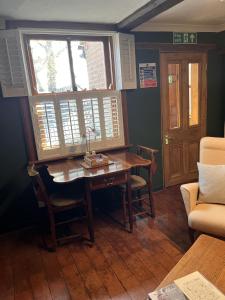 a dining room with a table and two windows at The Globe House in Broseley