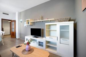 a living room with a desk with a computer monitor at Piso arquillo del reloj in Chiclana de la Frontera