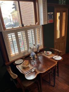 a dining room table with chairs and a table and a window at The Globe House in Broseley