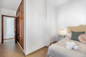a bedroom with a bed with two towels on it at Piso arquillo del reloj in Chiclana de la Frontera