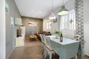 a kitchen and living room with a table and a couch at Piso arquillo del reloj in Chiclana de la Frontera