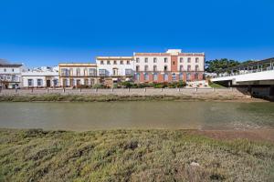 a group of buildings next to a body of water at Piso arquillo del reloj in Chiclana de la Frontera