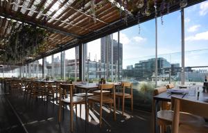 a restaurant with tables and chairs and large windows at Boundary Shoreditch in London