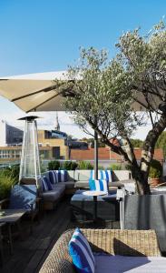 a patio with couches and tables and an umbrella at Boundary Shoreditch in London