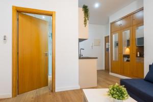a living room with a blue couch and a kitchen at Moderno Estudio Junto Al Río in Seville
