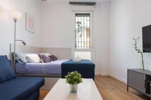 a small living room with a bed and a table at Moderno Estudio Junto Al Río in Seville