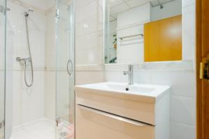 a white bathroom with a sink and a shower at Moderno Estudio Junto Al Río in Seville +11 photos