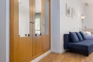 a living room with a blue couch and a wooden door at Moderno Estudio Junto Al Río in Seville