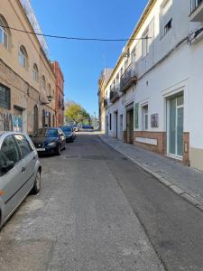 an empty street with cars parked on the sides of buildings at Moderno Estudio Junto Al Río in Seville