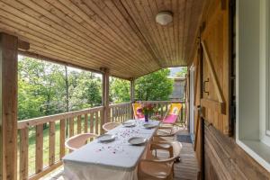 a long table on a deck with chairs on it at Maisons Cozy - Mas Lachamp in Gravières