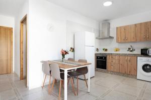 a kitchen with a table and chairs in a kitchen at Villa Montenmedio 1 in El Soto