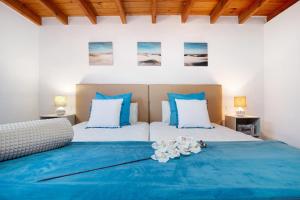 a bedroom with two beds with blue and white pillows at Casa Valentina in Tuineje +20 photos