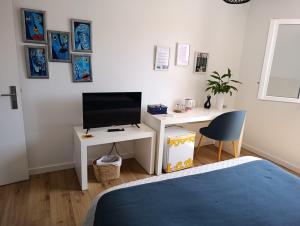 a bedroom with a bed and a desk with a television at Silver Home in Nazaré +74 photos